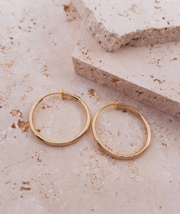 Créoles à clip dorées de 3 cm. Oreilles non percées.