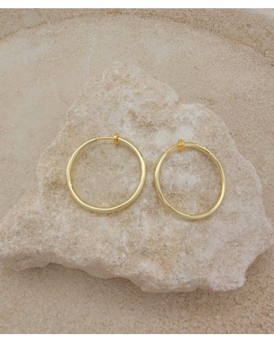 Créoles à clip dorées de 3 cm. Oreilles non percées.