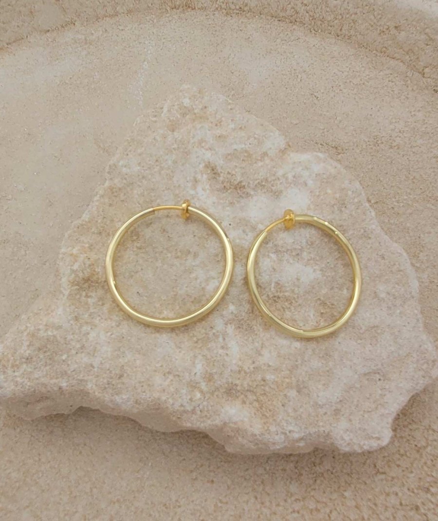 Créoles à clip dorées de 3 cm. Oreilles non percées.